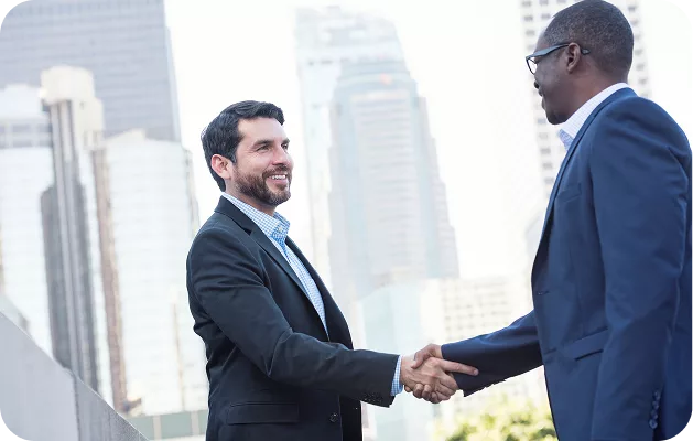 Business professionals shaking hands in Chicago, representing a successful partnership with KWPMC Midwest for property management services.